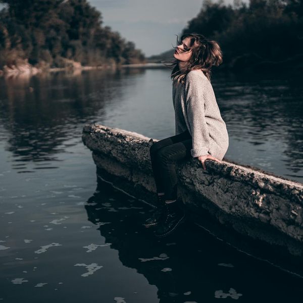 Person meditating peacefully in a calm, dark environment.